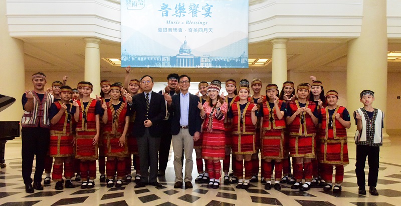 六龜育幼院合唱團於奇美博物館大廳快閃演唱,與臺灣銀行呂董事長桔誠(前排左五)、奇美博物館許館長家彰(前排左六)合影留念。