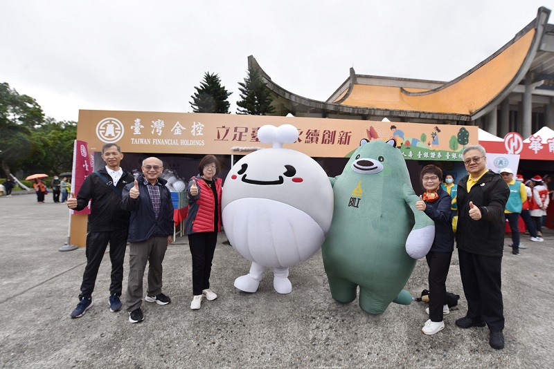 臺灣金控總經理施瑪莉 (左三)、臺銀人壽總經理劉啟聖 (右一)、臺銀證券董事長許慈美(右二)、臺銀保經代理董事長何明堯 (左二)、臺灣銀行企劃部經理李明華(左一)及臺灣銀行吉祥物鯨魚BUBI、臺銀人壽吉祥物熊保合影